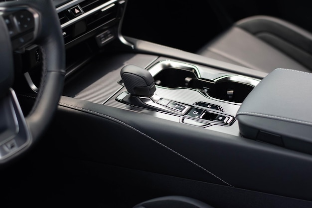 A car interior with a gear shift and a shift handle.