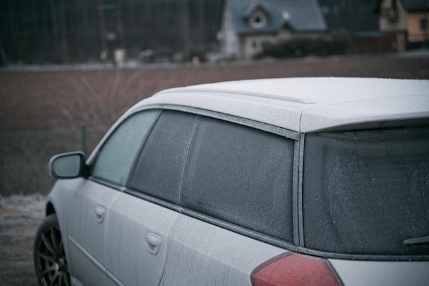 Car is covered with frost cold morning with a vehicle parked outside during night