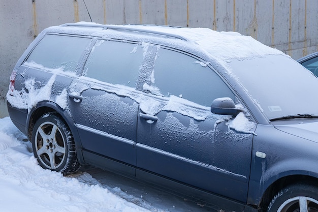 The car is covered with snow after a snowfall