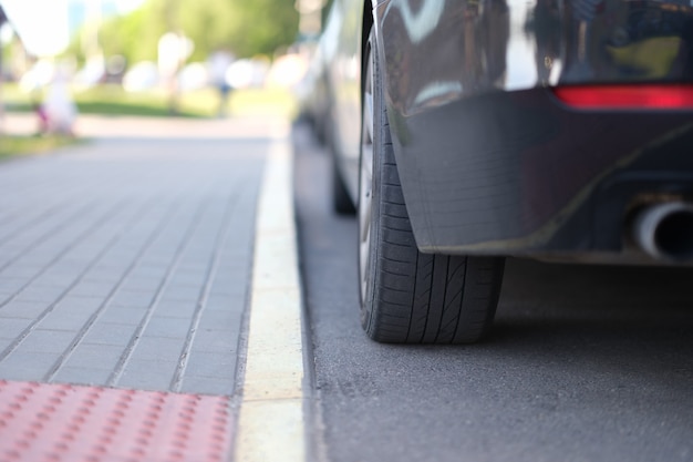 Photo car is parked near yellow median strip closeup