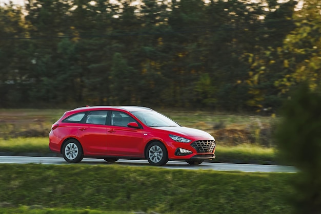 A car journey captured against the backdrop of a serene forest landscape under the enchanting light of dusk Modern family vehicle moving on the highway Sustainable trip