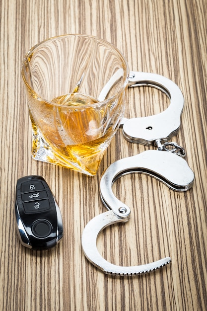 Car key on the bar with spilled alcohol