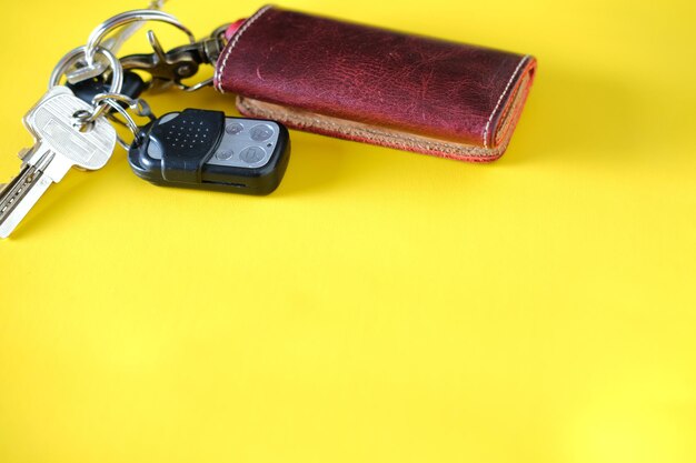 Car key isolated on yellow background. Top view close up details.