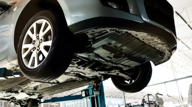 Car on the Lift Up Machine at the Car Repair Station. Fixing Services and Maintenance.