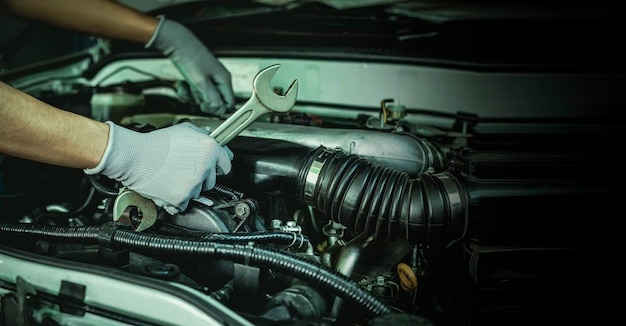 A car mechanic is doing a car repair in a repair shop