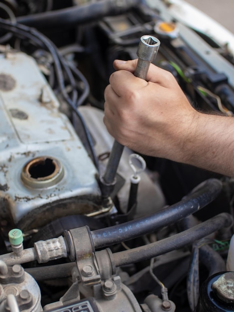 Car mechanic repairing engine in garage