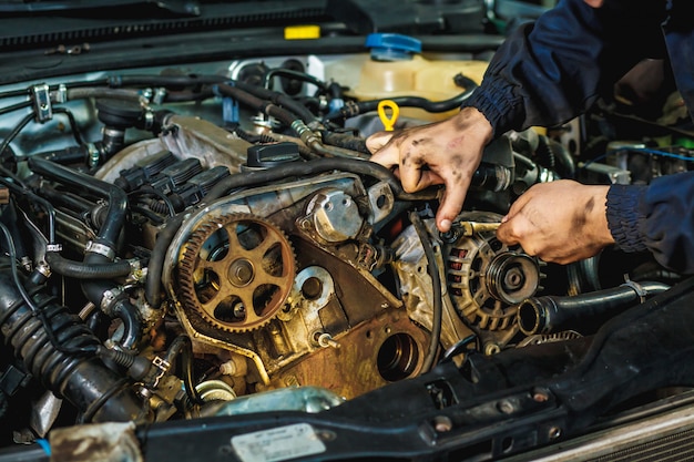 Car mechanic repairing an engine. Mechanic working on car engine. Mechanic workshop.