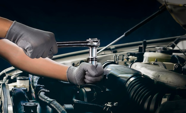 Car mechanic working on car engine car maintenance concept