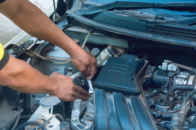 Car mechanic working with wrench in garage. Repair service.