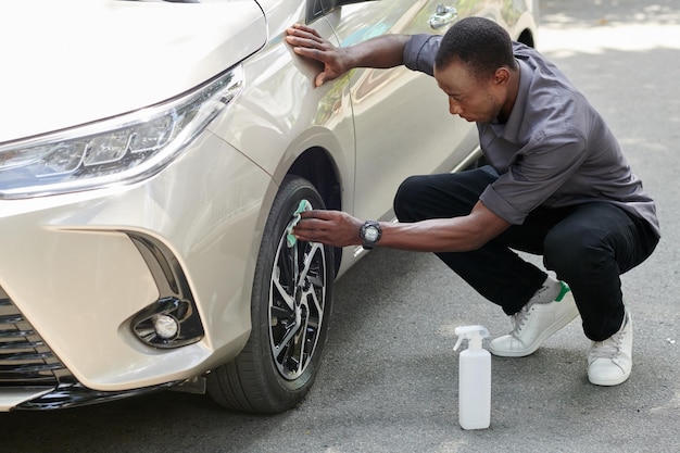 Car Owner Cleaning Alloy Rim