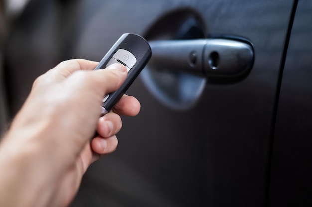 The car owner holds in his hand a remote control device for keyless entry