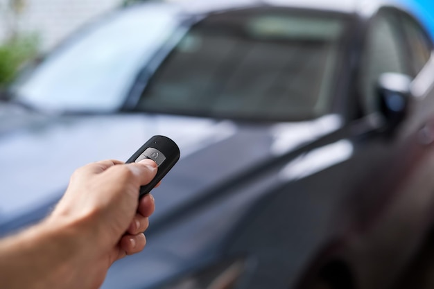 The car owner holds in his hand a remote control device for keyless entry