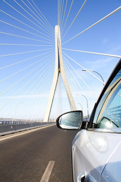 A car passing over a large white suspension bridge in Cadiz