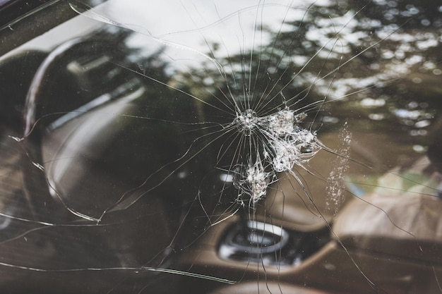 Car's cracked window with patterns and holes