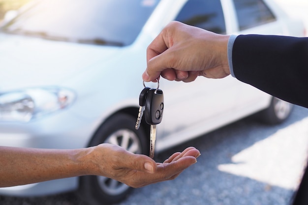 The car salesman and the key to the new owner.       