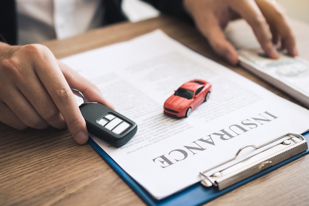 Car salespeople are holding car keys by submitting to new car buyers with car insurance concept