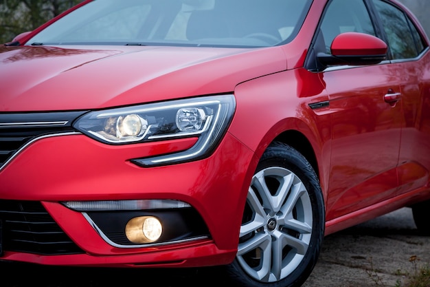 A car  Sedan red color is parked on the roadside