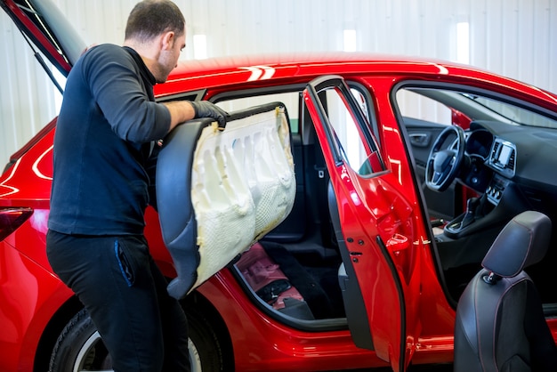 Car service worker disassemble the interior of the car