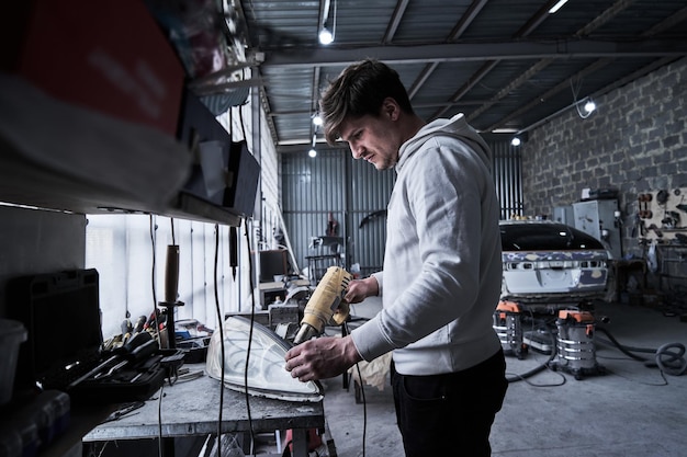 Car service worker repairs restores car