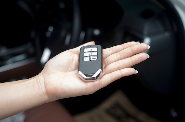 Car smart key is an electronic access and authorization system, Hand holding smart key of car.