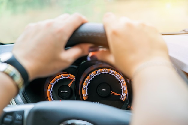 Car speedometer and female hands selective focus