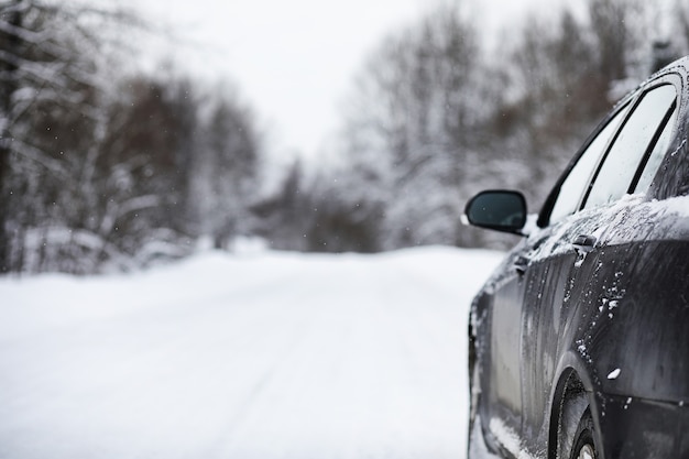 The car stands on a snow-covered road in a wintertime cloudy day