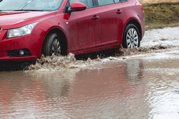 Car stuck in the mud, car wheel in dirty puddle, rough terrain