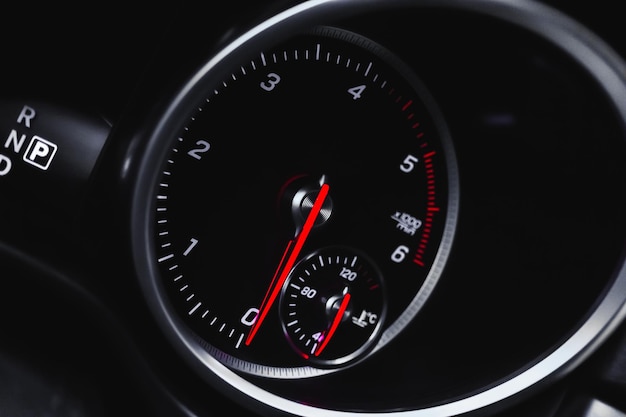 Car tachometer with glowing red indicators closeup view of luxury dashboard in sport car