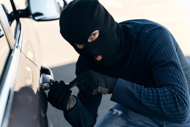 Car theft Thief trying to break into the vehicle Car thief trying to break into a car with a screwdriver Car thief concept