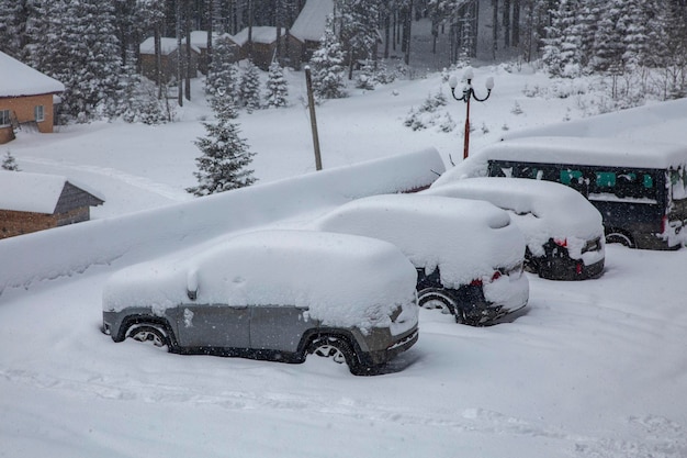 Car under a thick layer of snow Snowcovered cars during a winter blizzard