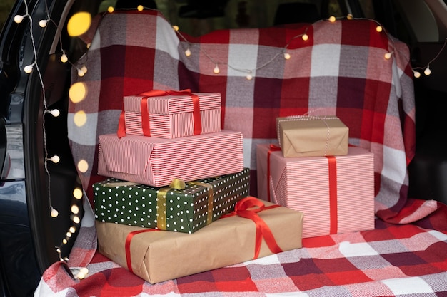 Car trunk full of gift boxes, presents and garland for Christmas holidays