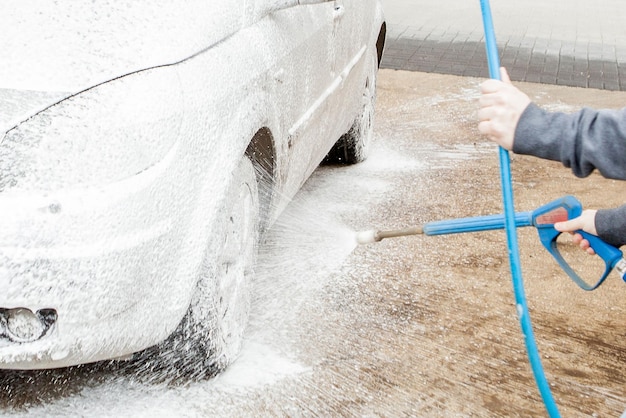 Car wash with foam in car wash station Carwash Washing machine at the station Car washing concept Car in foam