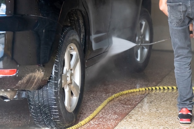 Car washing. Cleaning car with high pressure water and foam. Transportation