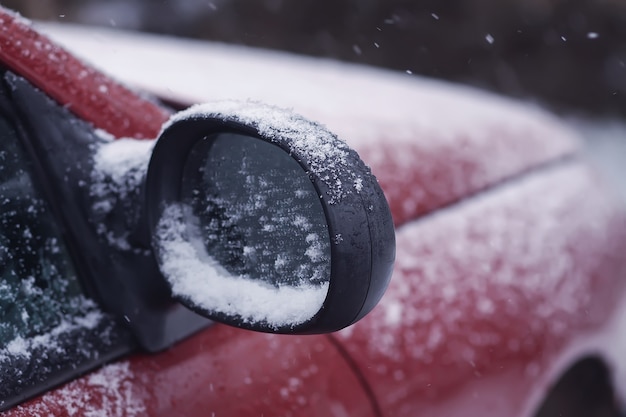 Car wing mirror covered up with fresh wet snow.