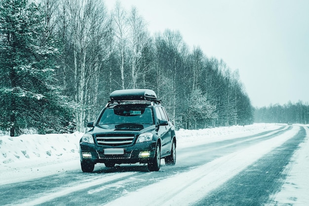 Car with roof rack in the winter snowy road of Rovaniemi in Lapland, Finland