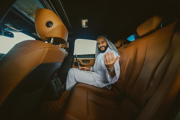 In a car A young rich saudi in a leather car interior