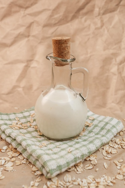 Carafe of milk and scattered oatmeal on crumpled paper background