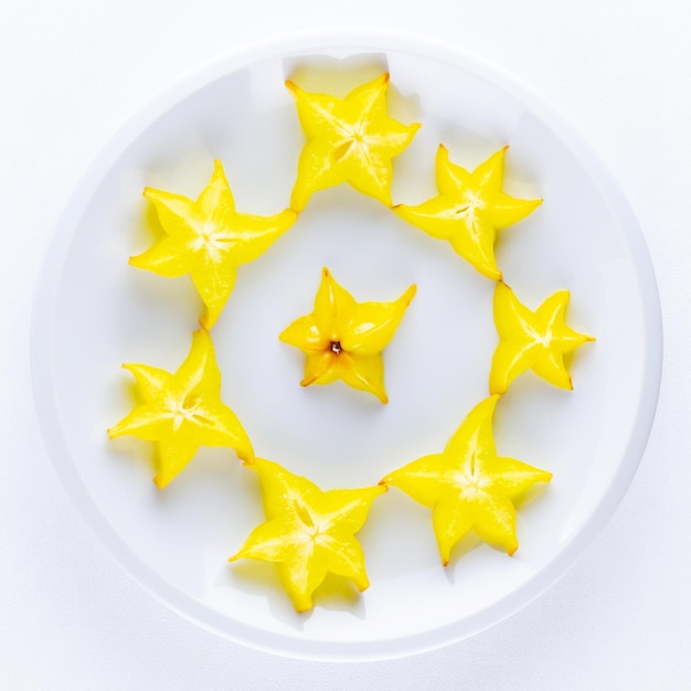 Carambola on white plate Sliced fresh carambola on white background Trendy food