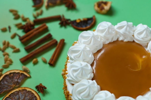 Caramel cake with nuts and caramel sauce glaze whipped cream with cinnamon rounded tart or pie