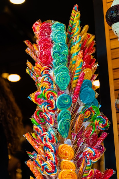 Caramel colored lollipops for children on sticks at entrance to market