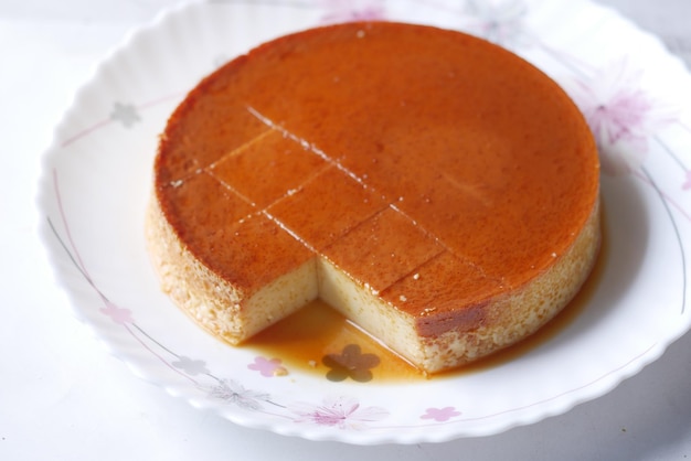 Caramel custard pudding on a plate on table