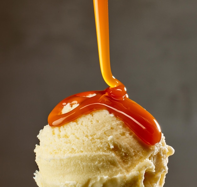 Photo caramel sauce flowing on vanilla ice cream