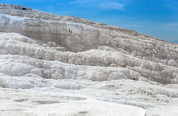 Carbonate mineral cliff with calcite-laden waters in Hierapolis Pamukkale in Turkey. Pamukkale is meaning cotton castle in Turkish, is a natural site in Denizli Province.