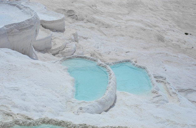 Carbonate mineral cliff with calcite-laden waters in Hierapolis Pamukkale in Turkey. Pamukkale is meaning cotton castle in Turkish, is a natural site in Denizli Province.