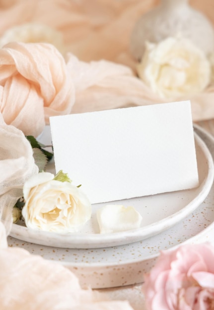 Card near cream tulle fabric on plates close up copy space wedding stationery mockup