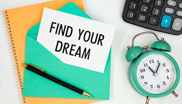 Card on a postal envelope with the text FIND YOUR DREAM, clock, calculator, pen.