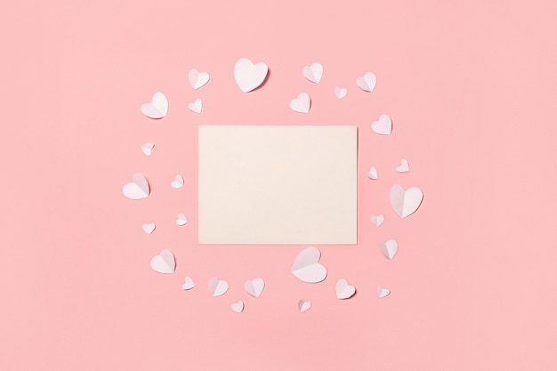 Photo card and white paper hearts on a pink background. composition valentine's day. banner. flat lay, top view.