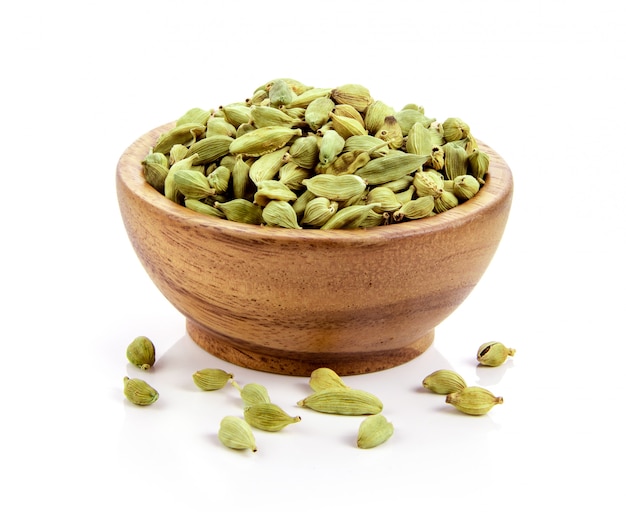 Cardamom in wood bowl isolated on White surface