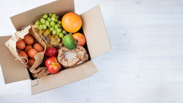 Cardboard box full of fruits vegetables beans egg from farmers market Ecological organic food