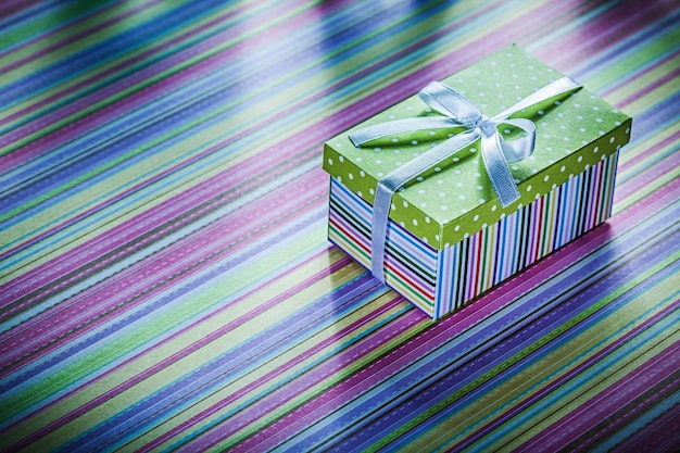 Cardboard box with gift on striped fabric celebrations concept